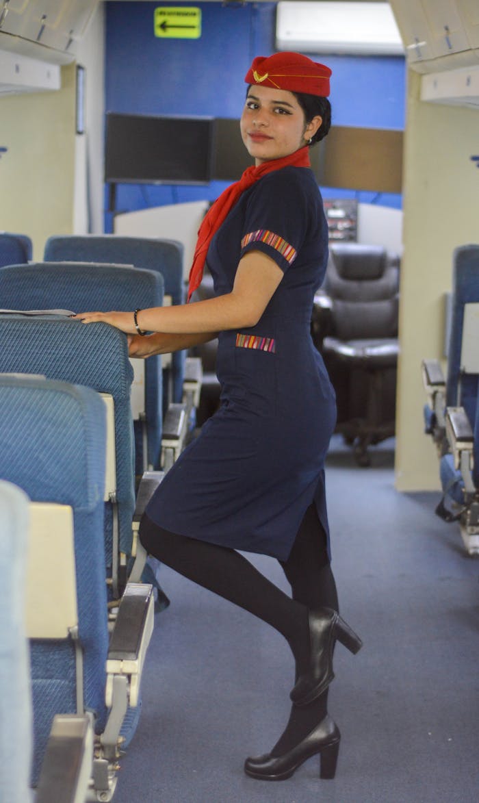 Professional flight attendant posing inside an aircraft cabin.
