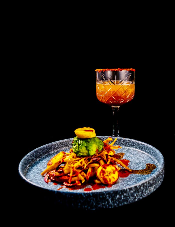 Delightful Mexican dish with a cocktail on a textured blue plate, perfect for culinary enthusiasts.