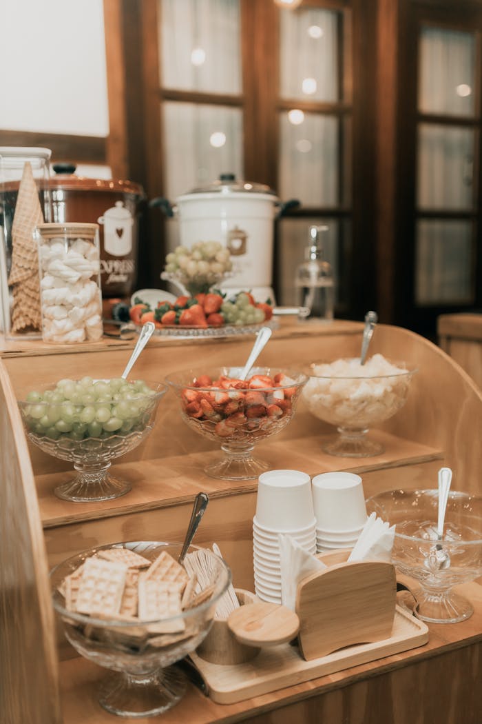 Elegant buffet setup featuring fresh fruits, snacks, and beverages in a cozy indoor setting.